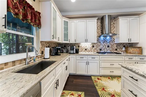 a kitchen with stainless steel appliances granite countertop a sink refrigerator and cabinets