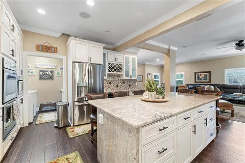 a kitchen with stainless steel appliances kitchen island granite countertop a refrigerator oven stove and cabinets