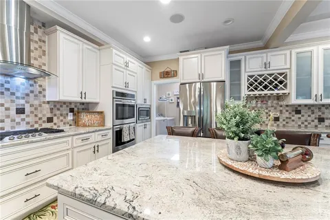 a kitchen with stainless steel appliances a dining table chairs and wooden floor