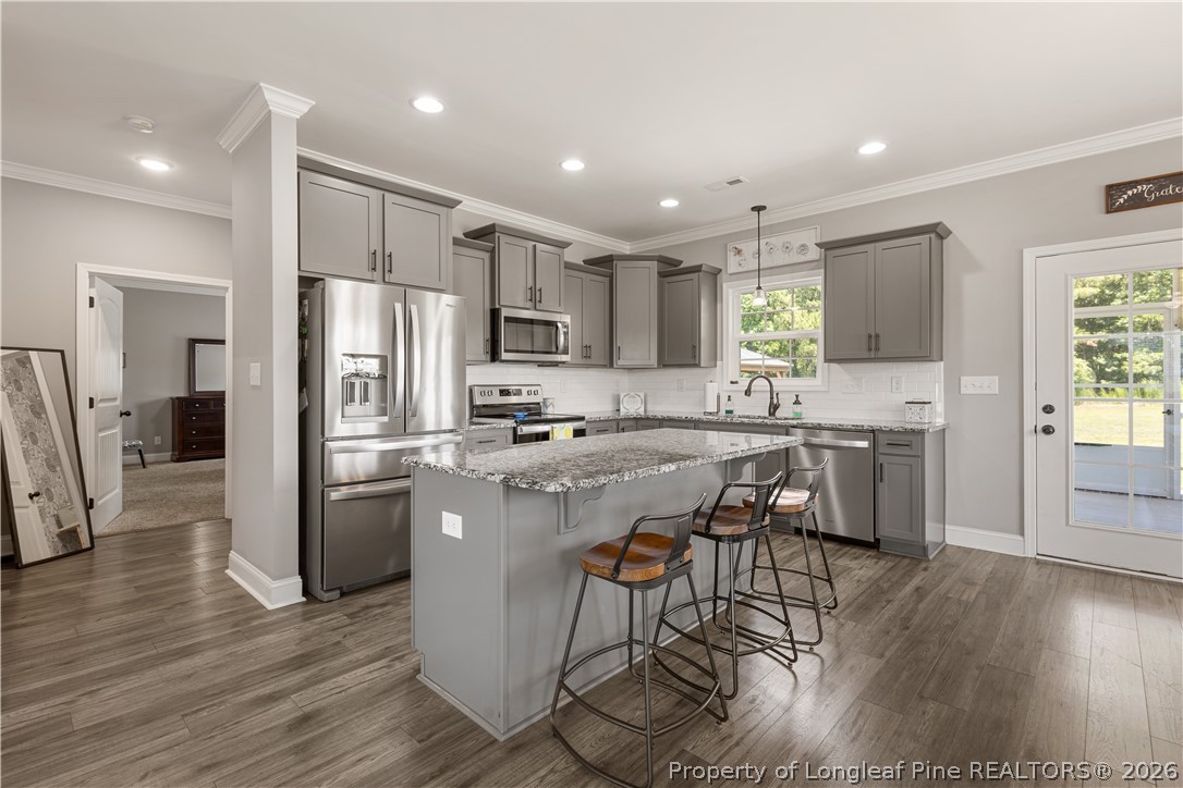 137 Minter School Road Sanford, NC 27332 - Photo 7 of 50 a kitchen with stainless steel appliances a dining table chairs refrigerator and cabinets