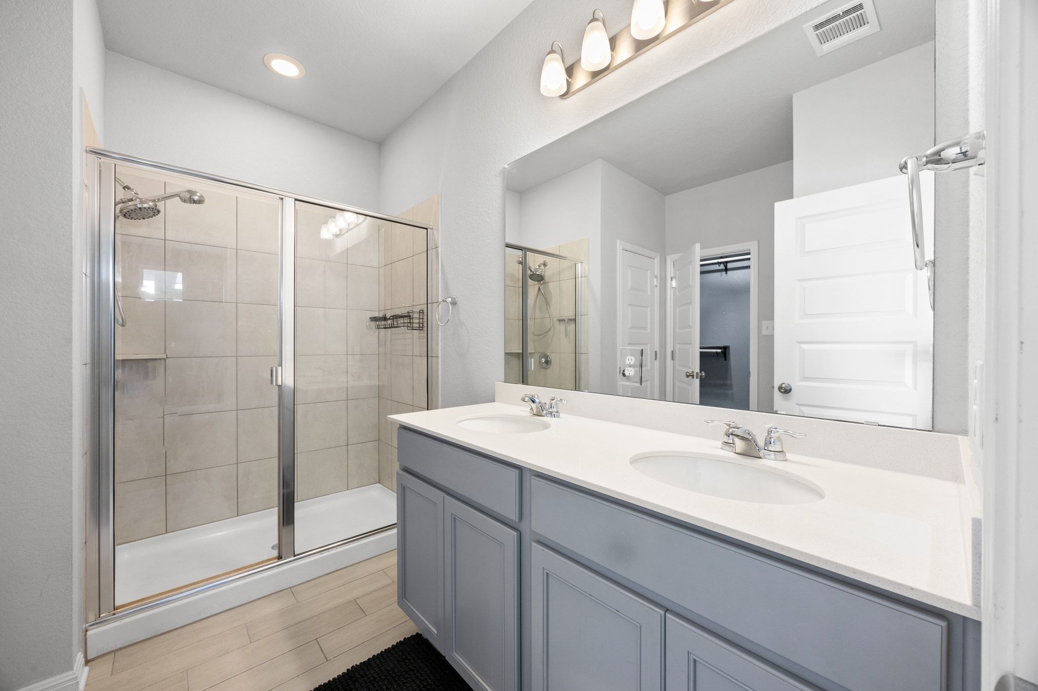 225 Unforgiven Lane Jarrell, TX 76537 - Photo 16 of 30 Bathroom featuring double vanity, a stall shower, and wood tiled floors