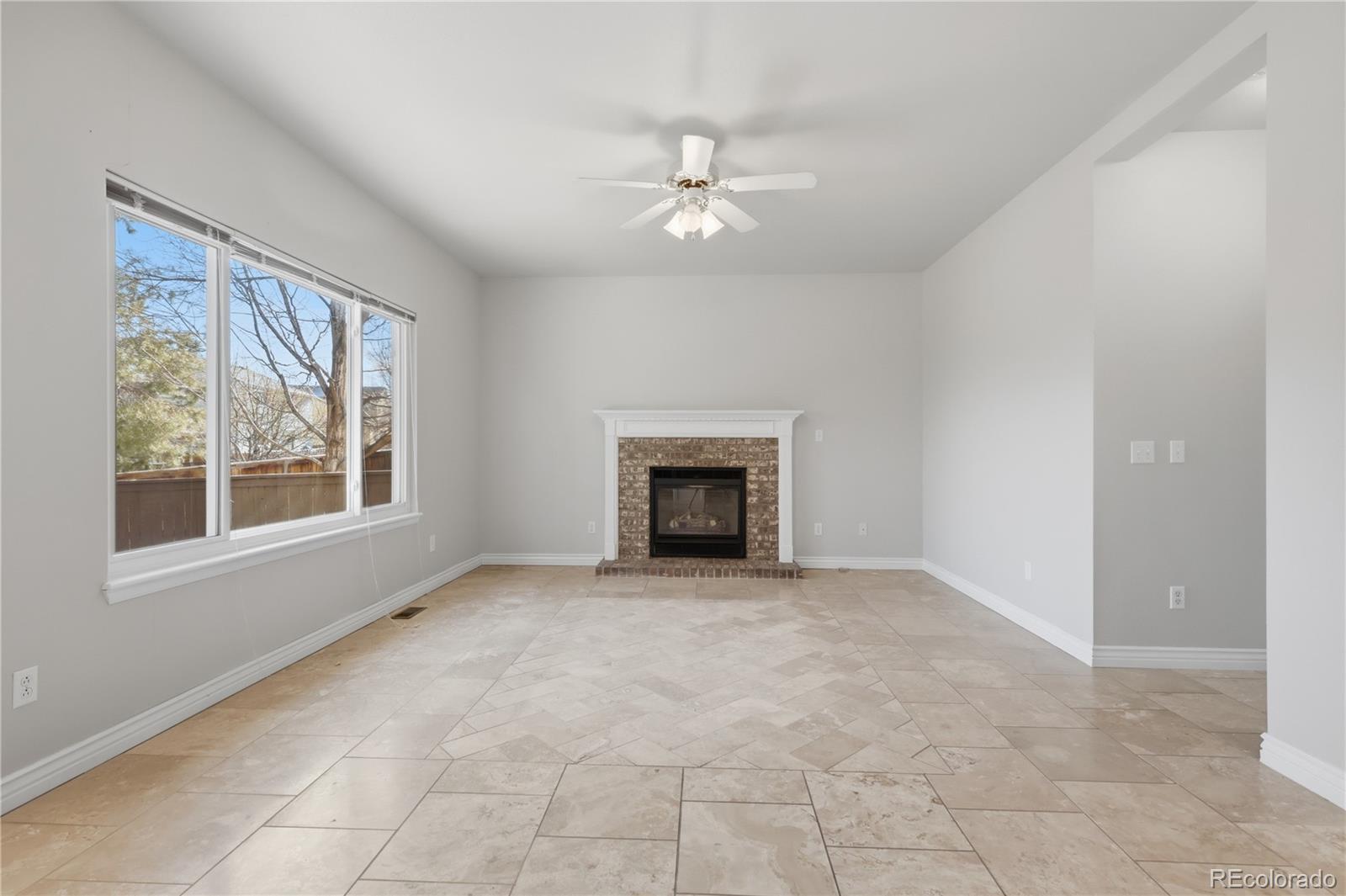 3807 Garnet Way Highlands Ranch, CO 80126 - Photo 16 of 38 an empty room with windows and fireplace