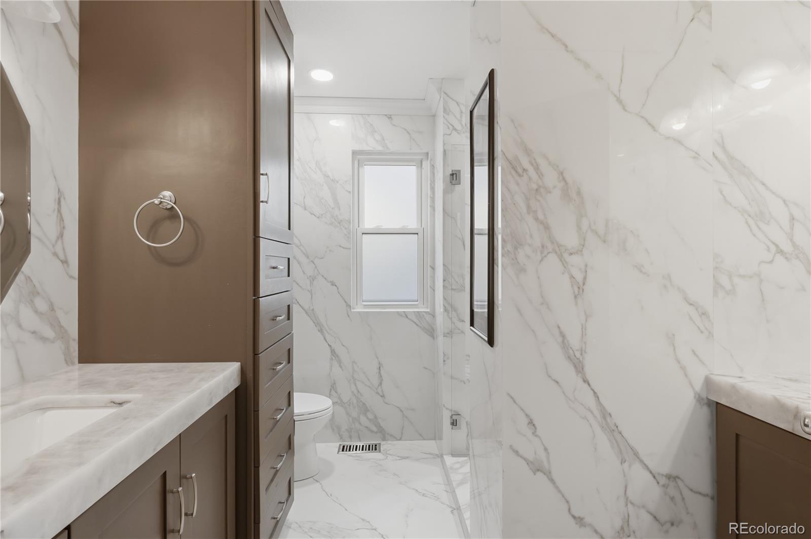 3807 Garnet Way Highlands Ranch, CO 80126 - Photo 23 of 38 a bathroom with a granite countertop sink a toilet and shower