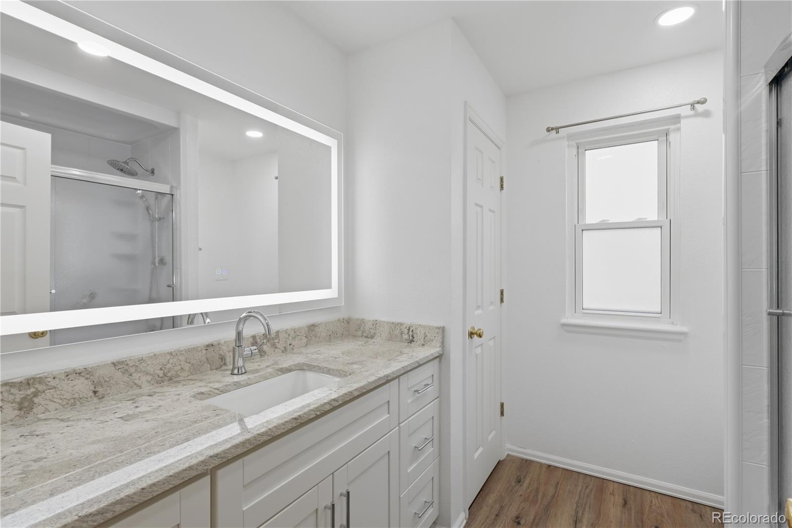 3807 Garnet Way Highlands Ranch, CO 80126 - Photo 27 of 38 a bathroom with a granite countertop sink and a mirror