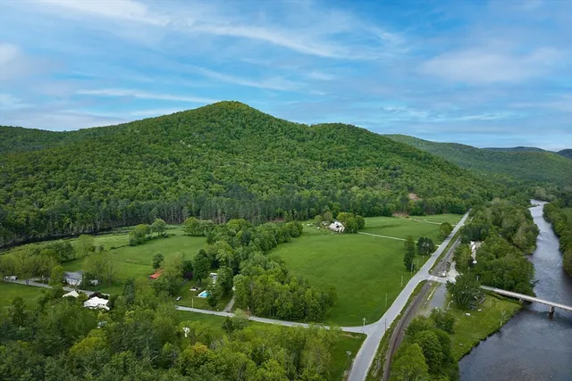 a view of a lush green field with a view of mountains in the background