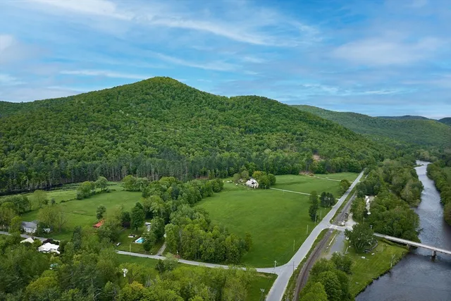 a view of a lush green field with a view of mountains in the background
