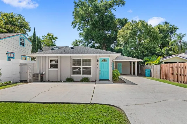 a front view of a house with a yard and potted plants