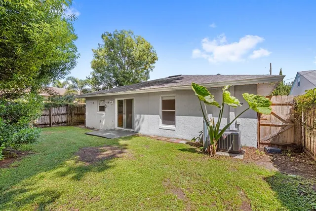 a view of a house with backyard and sitting area