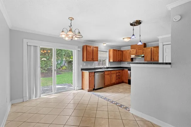 a large kitchen with granite countertop a stove a sink dishwasher and a wooden cabinets