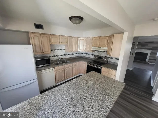 a kitchen with a sink a stove and cabinets