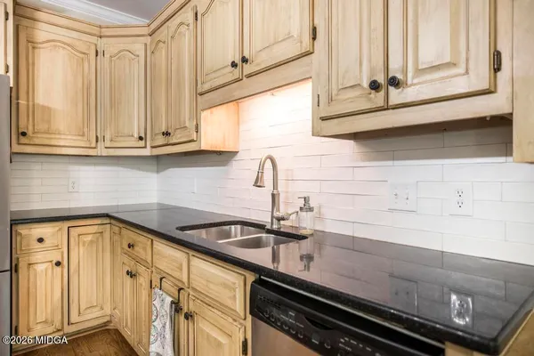 a kitchen with granite countertop a sink and cabinets