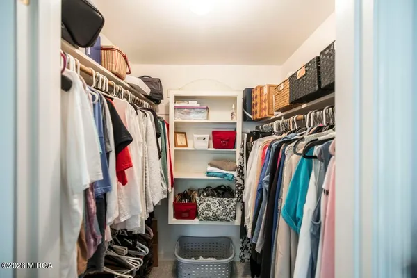a view of a hallway with bathroom and wooden floor