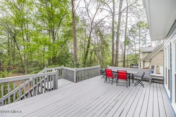 a view of a house with wooden fence next to a yard