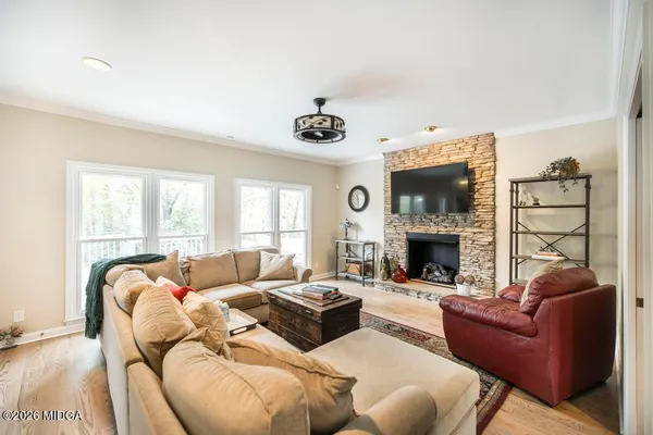 a living room with furniture a fireplace and a large window