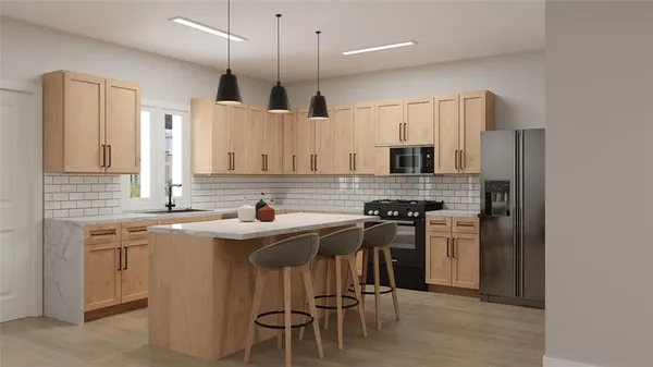 a kitchen with stainless steel appliances granite countertop a sink a stove a refrigerator and island