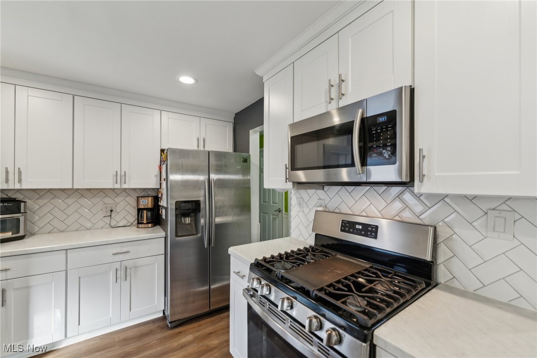 3885 Shields Road Canfield, OH 44406 - Photo 29 of 38 Kitchen with stainless steel appliances, white cabinetry, recessed lighting, dark wood-style flooring, and tasteful backsplash
