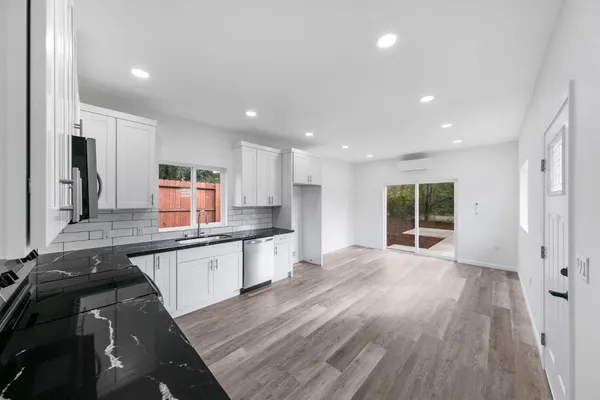 a large kitchen with stainless steel appliances granite countertop a large counter top a sink and a stove