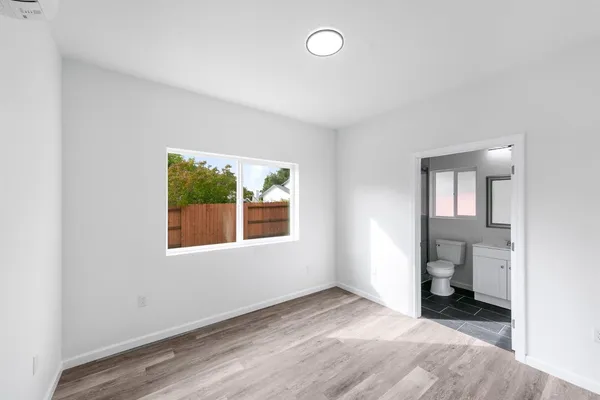 an empty room with a bathroom and a window