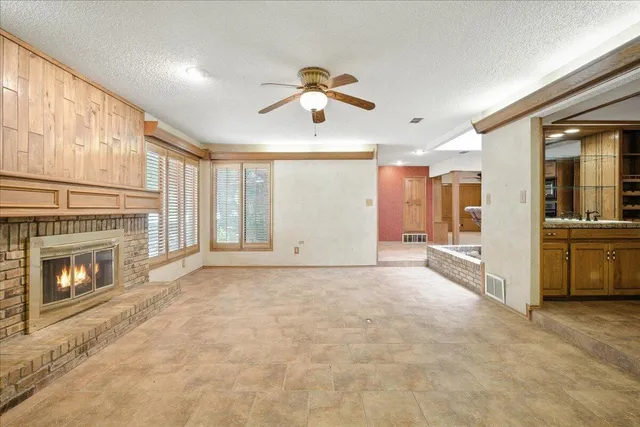 a view of an empty room with a fireplace and a window