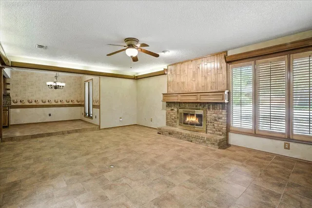 a view of empty room with a fireplace and fan