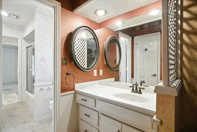 a bathroom with a granite countertop sink toilet and shower
