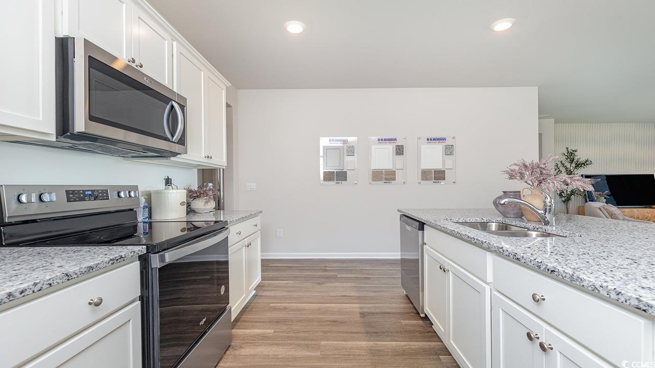 7350 Meadow Walk Loop Loris, SC 29569 - Photo 13 of 26 Kitchen featuring stainless steel appliances, light stone countertops, sink, and white cabinets