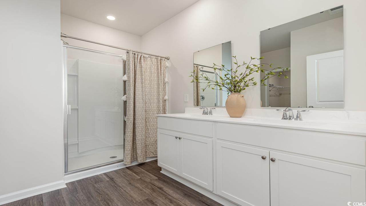 7350 Meadow Walk Loop Loris, SC 29569 - Photo 21 of 26 Bathroom featuring vanity, curtained shower, and hardwood / wood-style floors