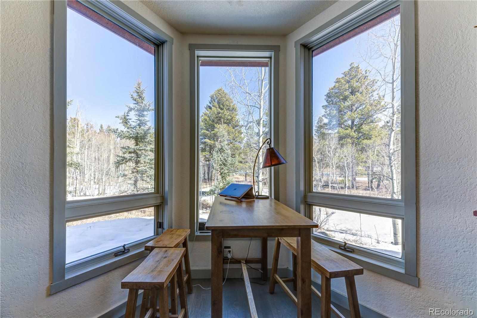 186 Thunder Ridge Road South Nederland, CO 80466 - Photo 17 of 50 a view of a room with a large window and dining table