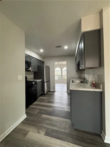 a kitchen with kitchen island granite countertop a sink and a stove top oven