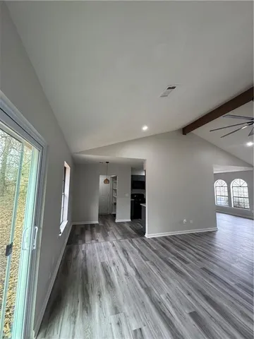 a view of empty room with wooden floor