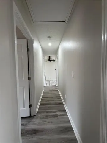 a view of a hallway with wooden floor and staircase