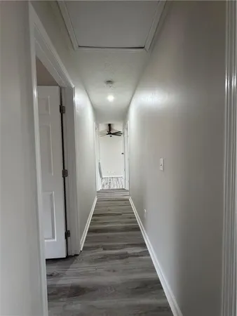 a view of a hallway with wooden floor and staircase