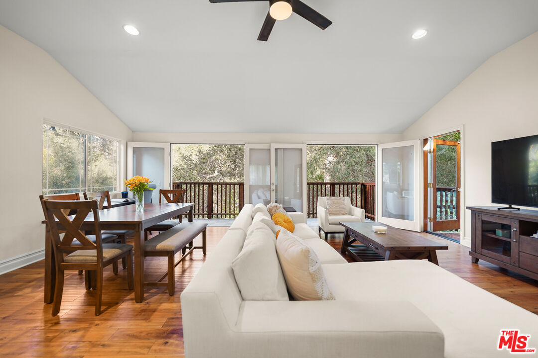 21545 Dome Trail Topanga, CA 90290 - Photo 2 of 23 a living room with furniture a flat screen tv and a large window