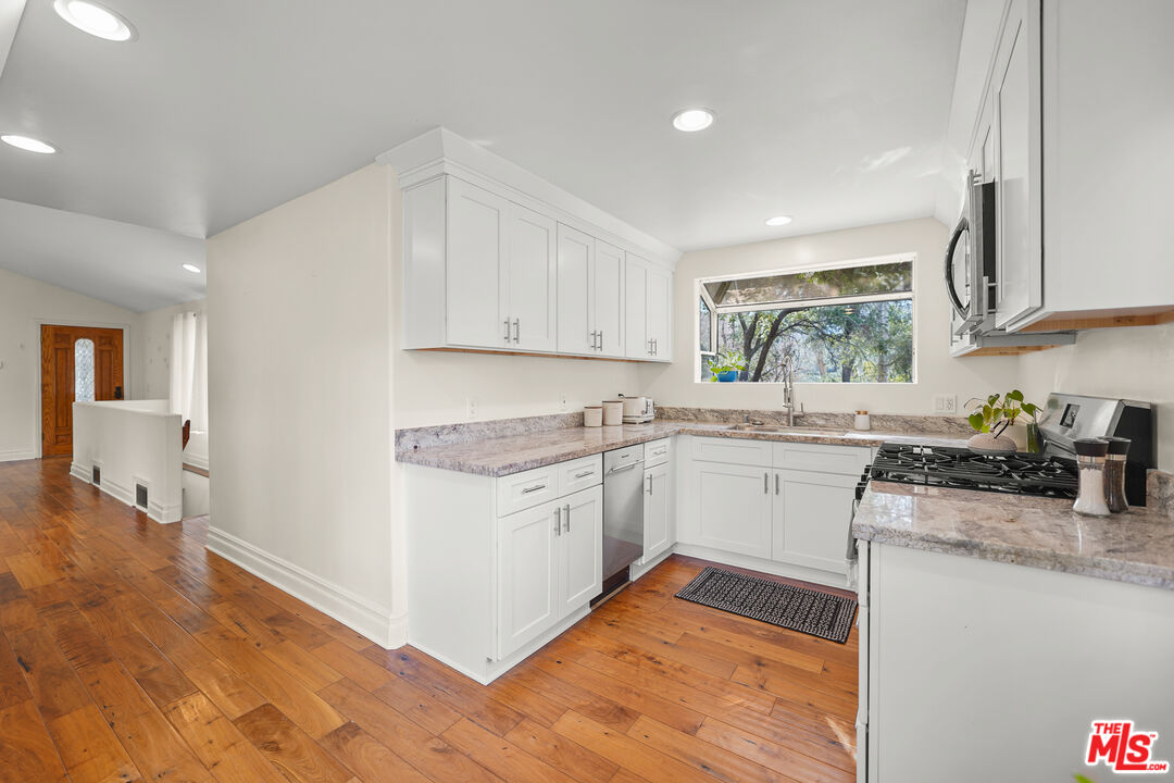 21545 Dome Trail Topanga, CA 90290 - Photo 5 of 23 a kitchen with granite countertop cabinets stainless steel appliances and a sink