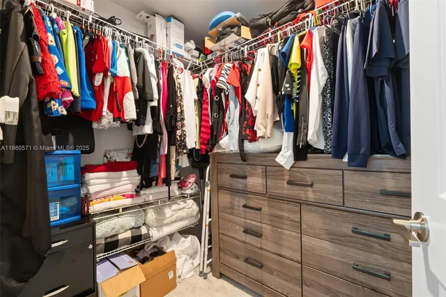 a view of walk in closet with clothes