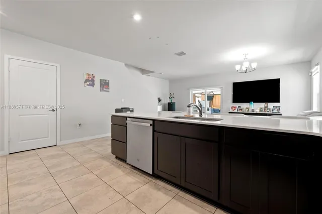 a kitchen with a sink and a stove top oven with wooden floor