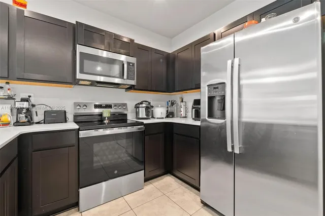 a kitchen with stainless steel appliances granite countertop a refrigerator and a sink