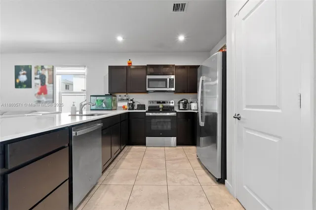a kitchen with stainless steel appliances granite countertop a refrigerator and a sink