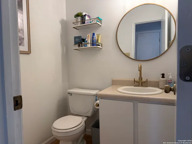 a bathroom with a toilet a sink and a mirror