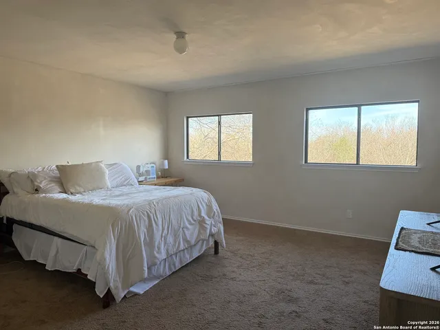 a spacious bedroom with a bed and window