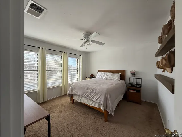 a spacious bedroom with a bed and a large window