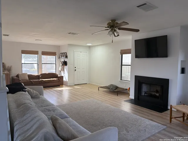 a living room with furniture a fireplace and a flat screen tv