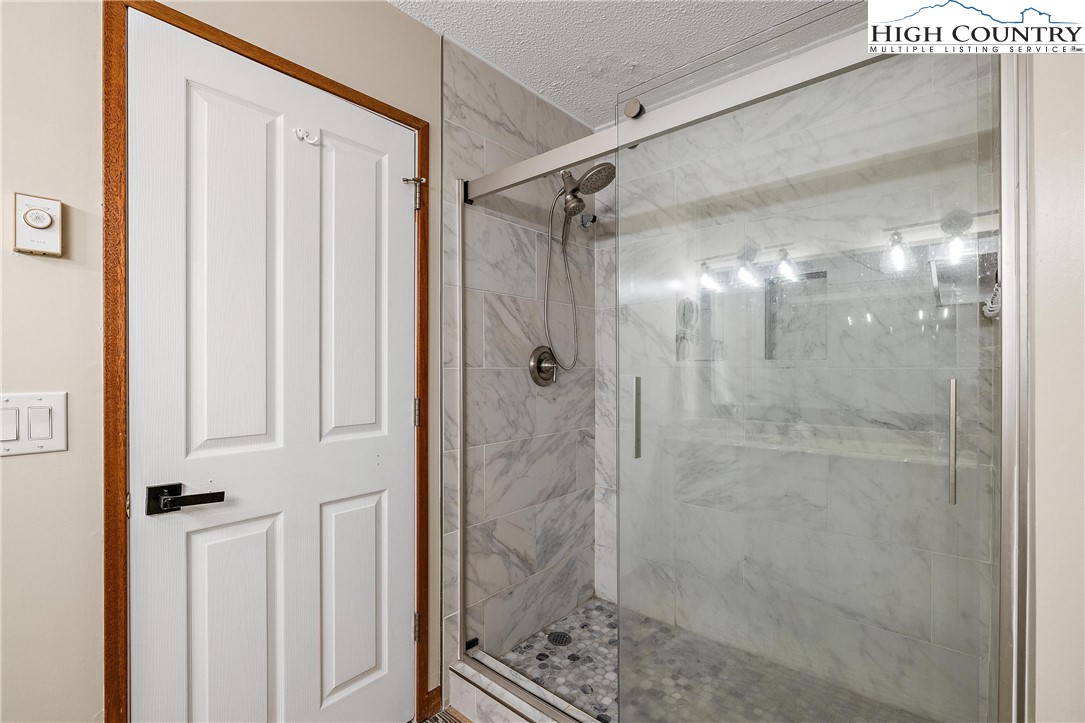 139 Club House Road Beech Mountain, NC 28604 - Photo 31 of 44 a bathroom with a glass shower door