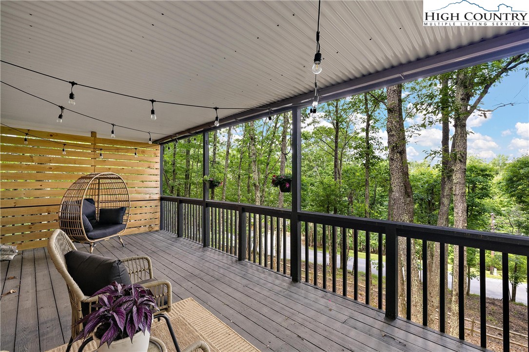 139 Club House Road Beech Mountain, NC 28604 - Photo 34 of 44 a view of a patio with table and chairs under an umbrella with wooden floor