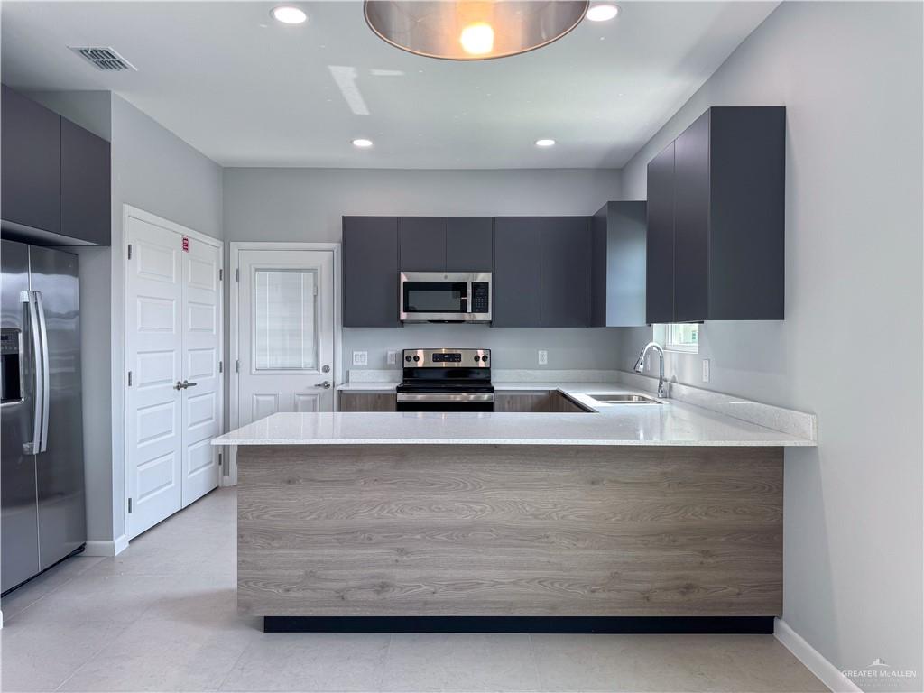 2705 Robin Road Weslaco, TX 78596 - Photo 2 of 8 a kitchen with stainless steel appliances granite countertop a stove a refrigerator and a microwave