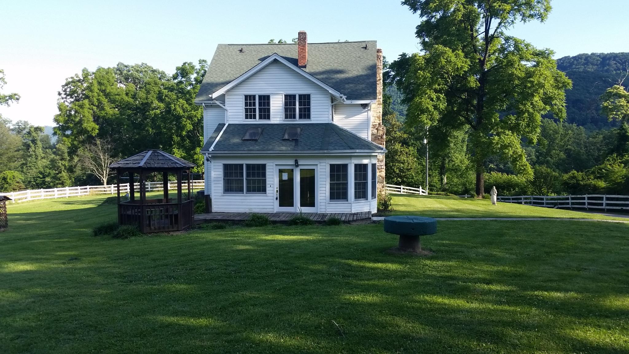 1145 Fralin Lane Blue Ridge, VA 24064 - Photo 3 of 12 a front view of a house with a garden and trees