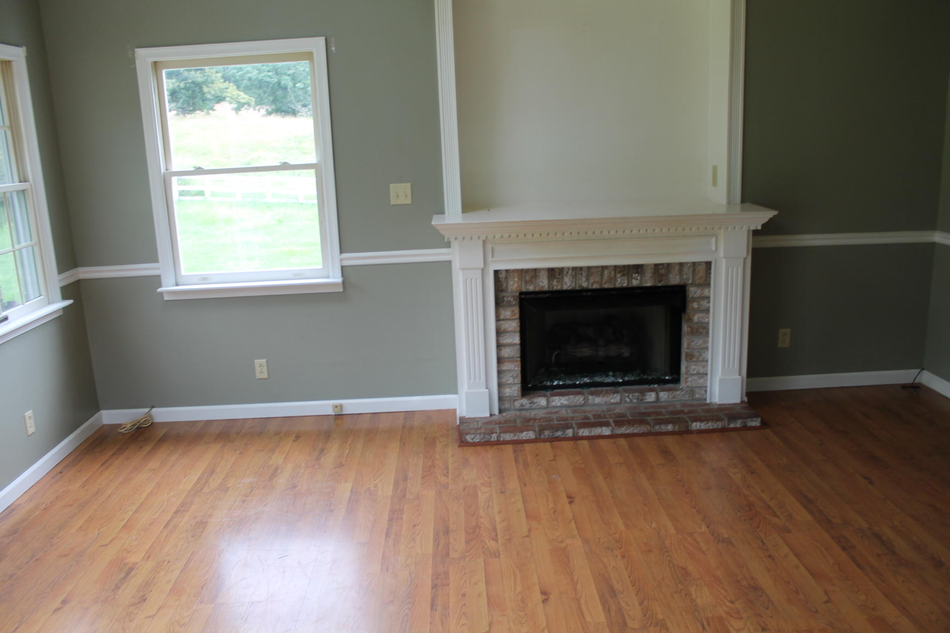 1145 Fralin Lane Blue Ridge, VA 24064 - Photo 10 of 12 an empty room with wooden floor fireplace and windows