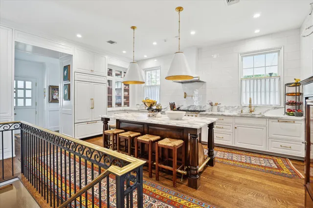 a open kitchen with stainless steel appliances granite countertop a stove a sink a oven and a dining table with wooden floor