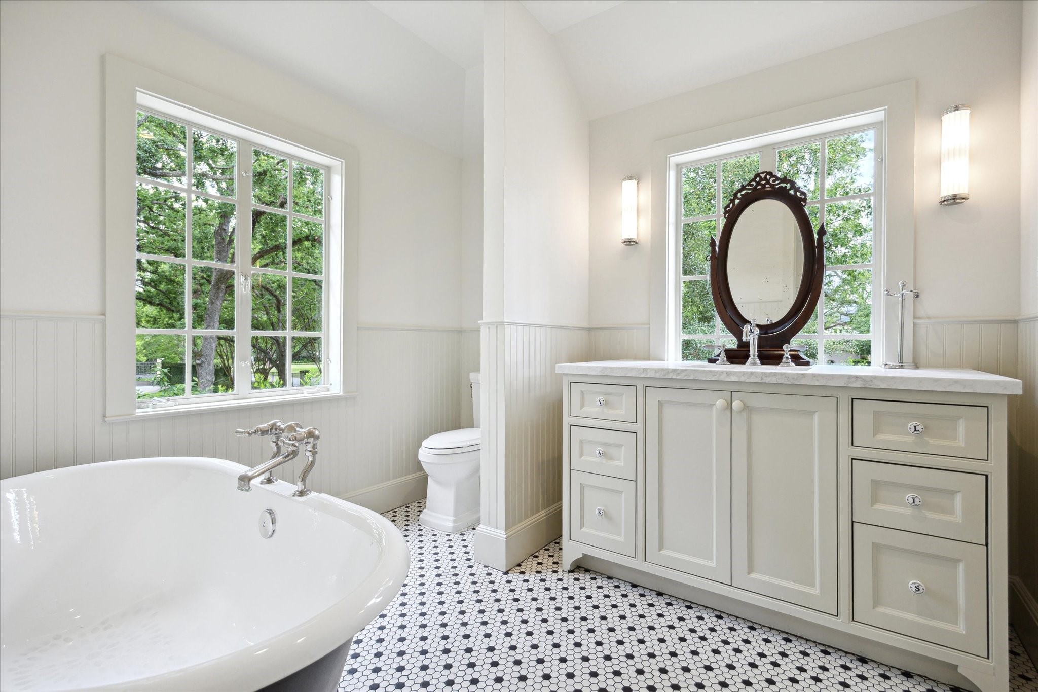 4019 Inverness Drive Houston, TX 77019 - Photo 41 of 49 a bathroom with a bathtub a sink a mirror and a window