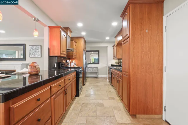 a large kitchen with stainless steel appliances a sink and counter top